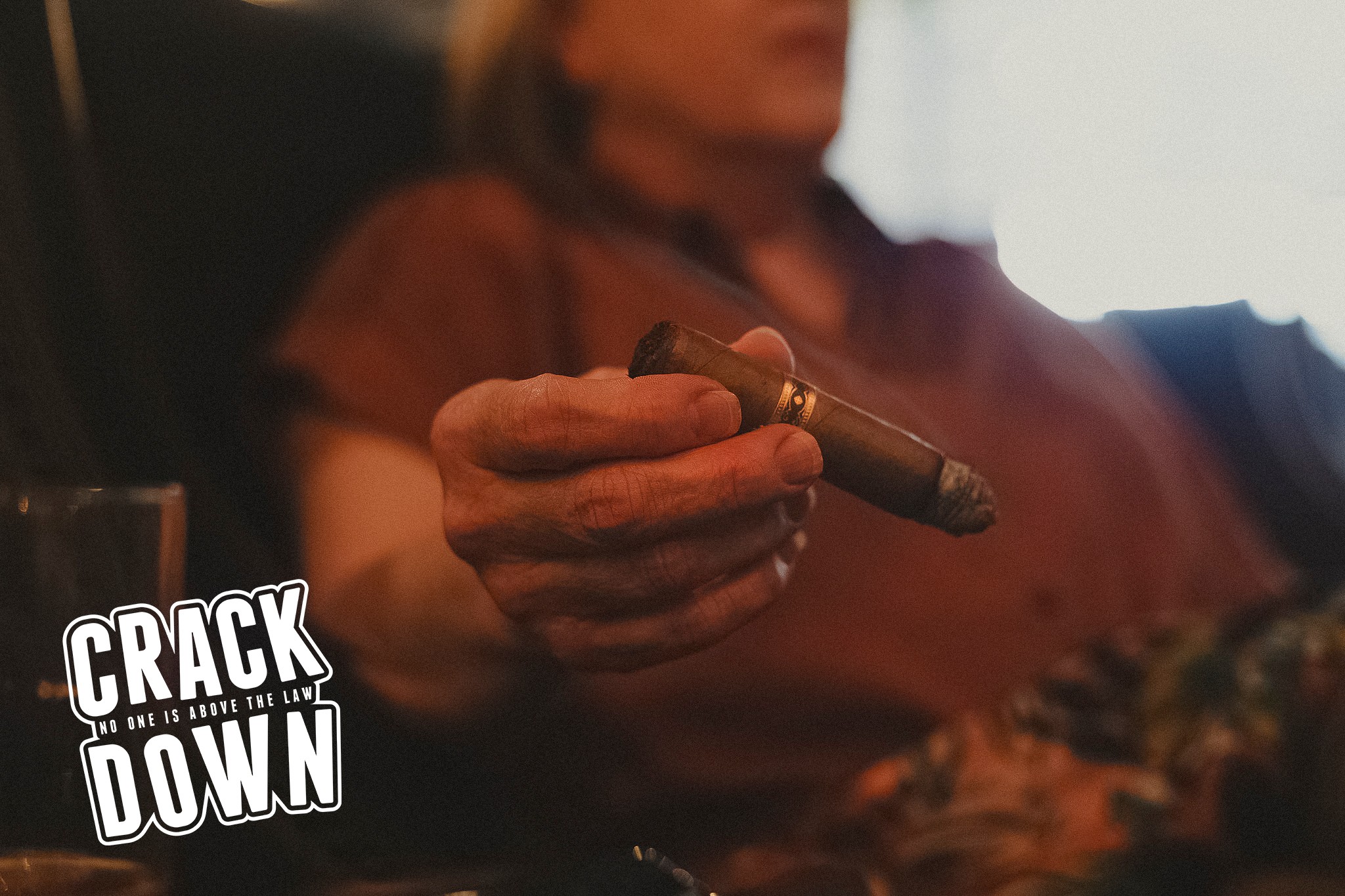 Person holding a cigar, with a