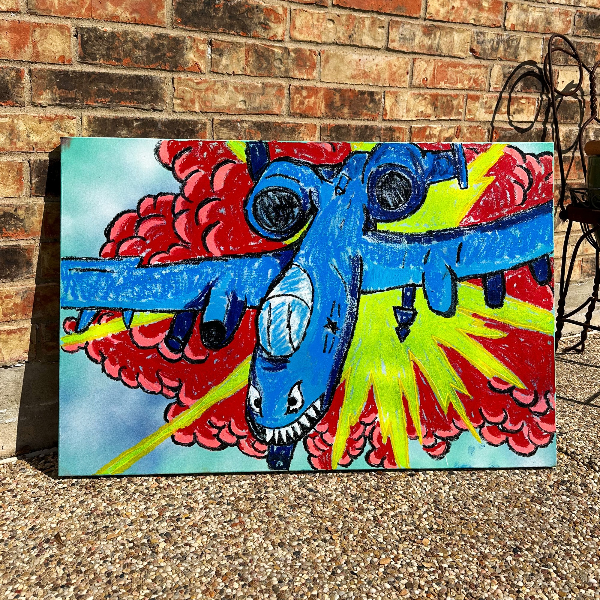 Colorful graffiti of a blue dragon with red clouds and yellow lightning on a brick wall background.