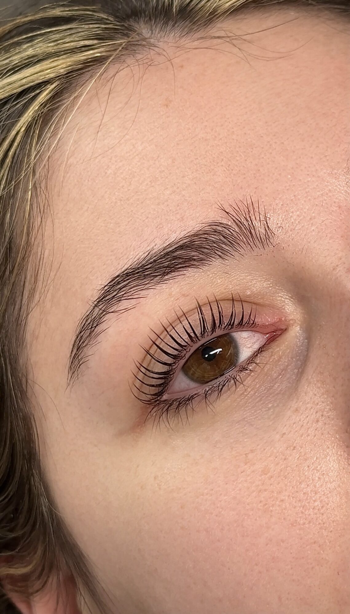 Close-up of a person's eye, showing eyebrow, eyelashes, and part of the forehead.