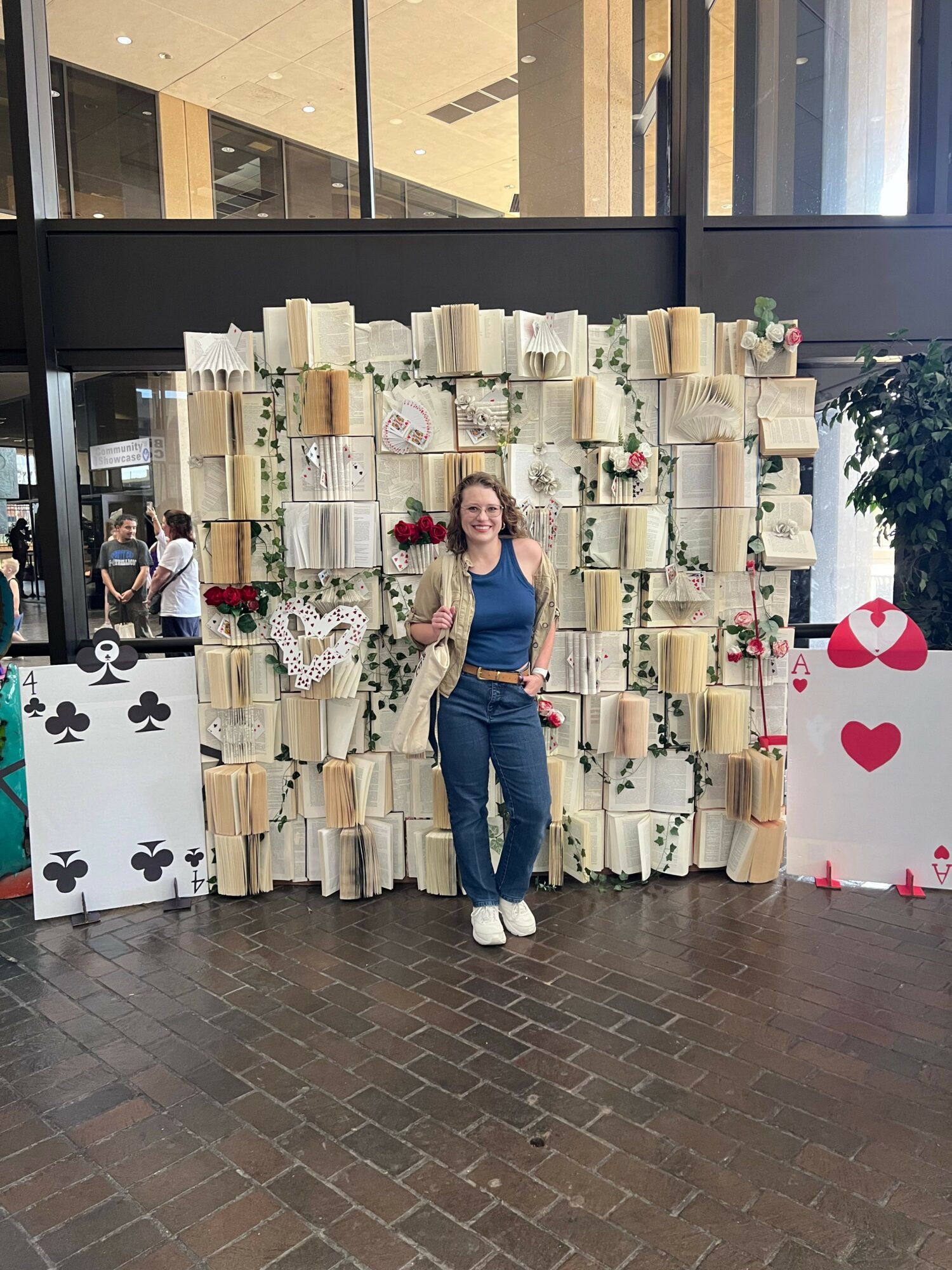 Person standing in front of a display of decorated white boxes with red and black hearts, flowers, and cards, on a brick floor.