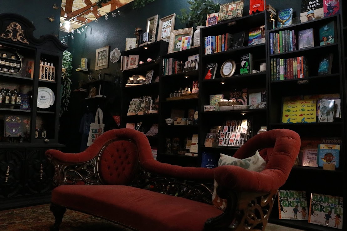 Bookshelves filled with books and decorative items in a cozy room with dark walls and warm lighting.