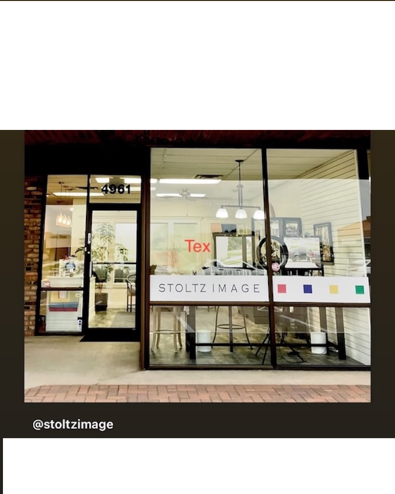 Storefront window with glass door and display window, interior visible, text on window, and a sidewalk outside.