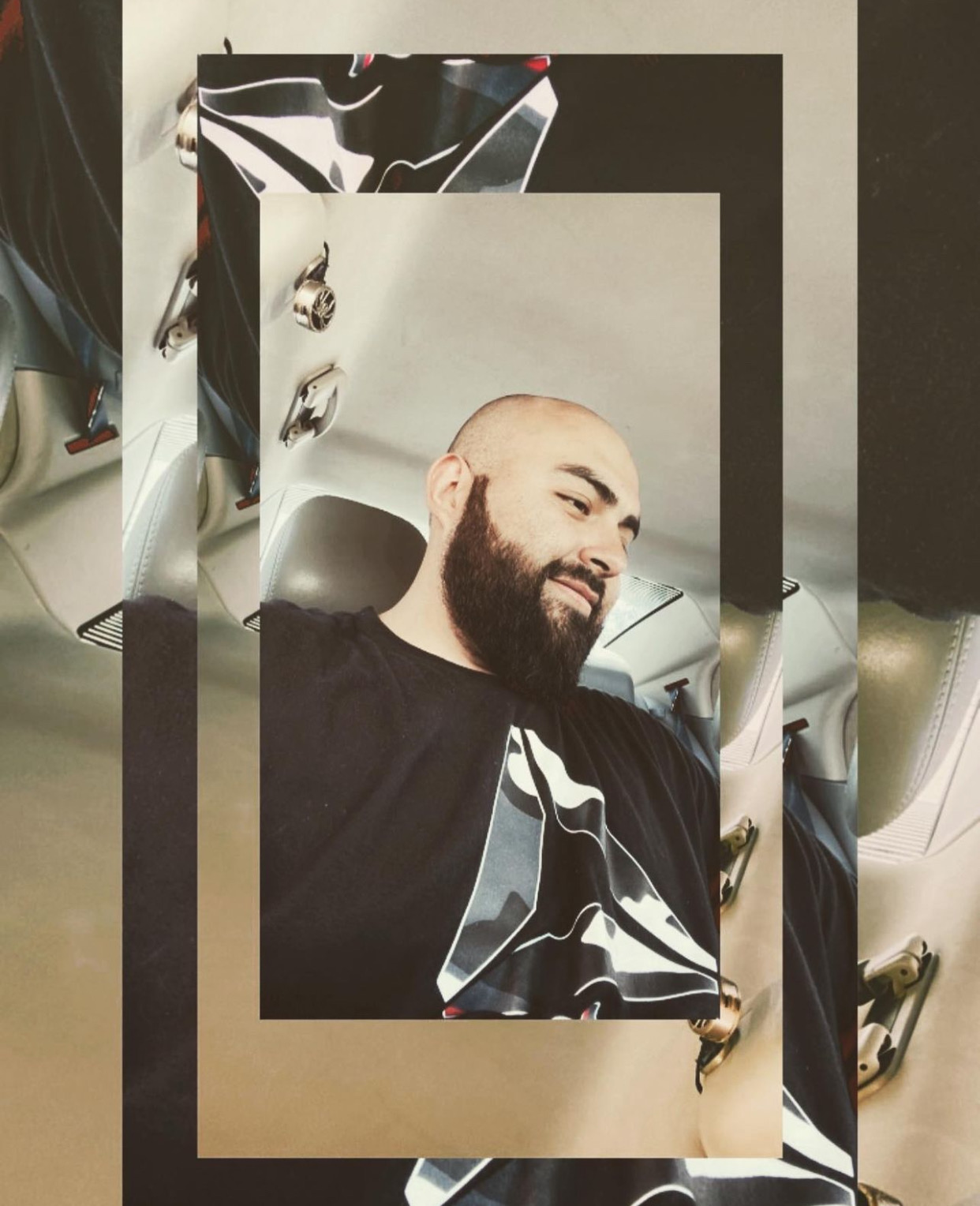 Man with a beard smiling, sitting in a car, with a layered, abstract background.