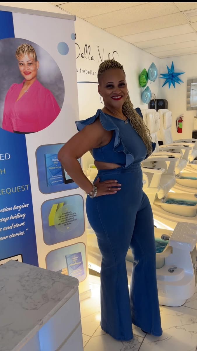 Woman in blue outfit smiling in a room with medical equipment and a poster of a woman with short blonde hair.