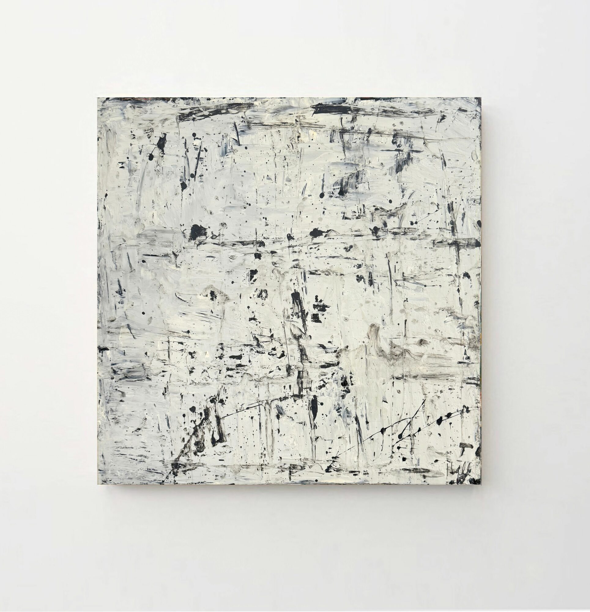 Abstract painting with black and white marks on a white background, square shape, mounted on a wall.