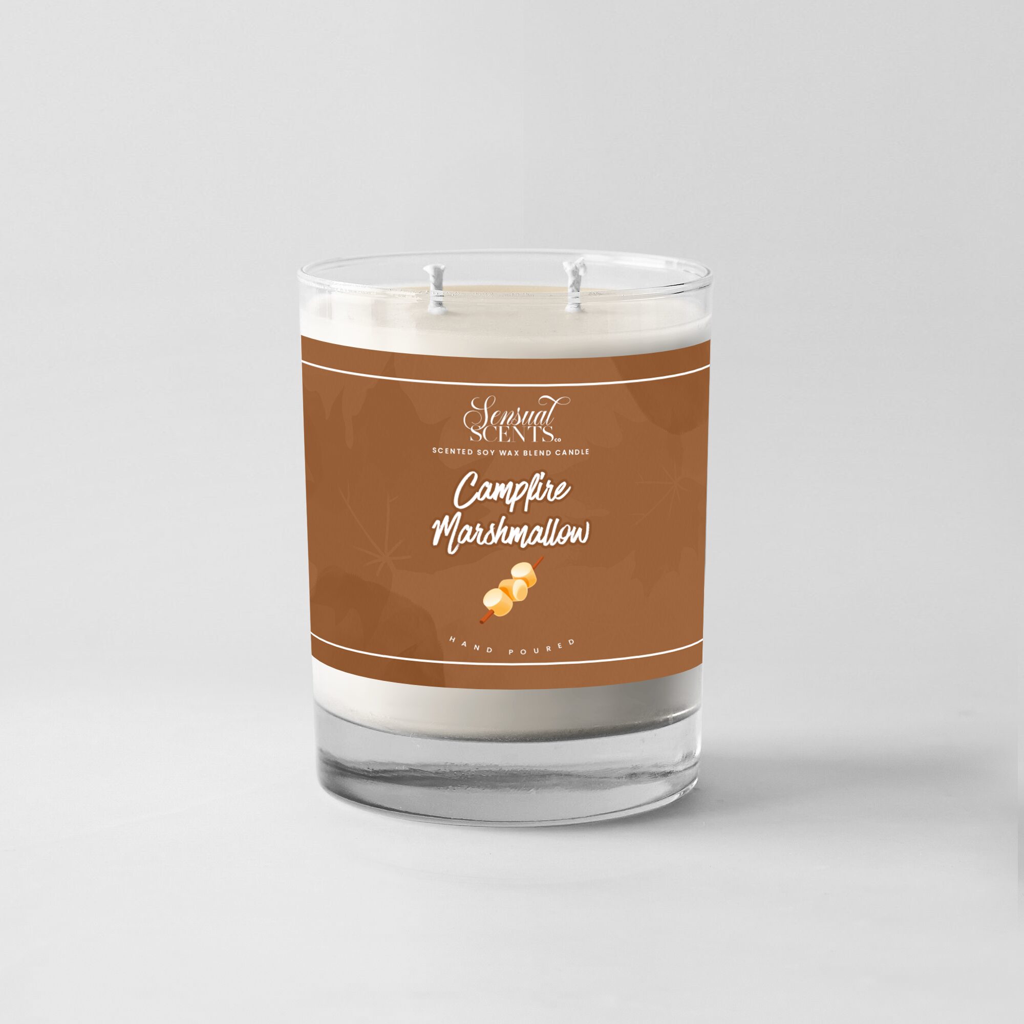 A candle in a glass jar with a brown label reading 'Campfire Marshmallow' and a small marshmallow illustration.