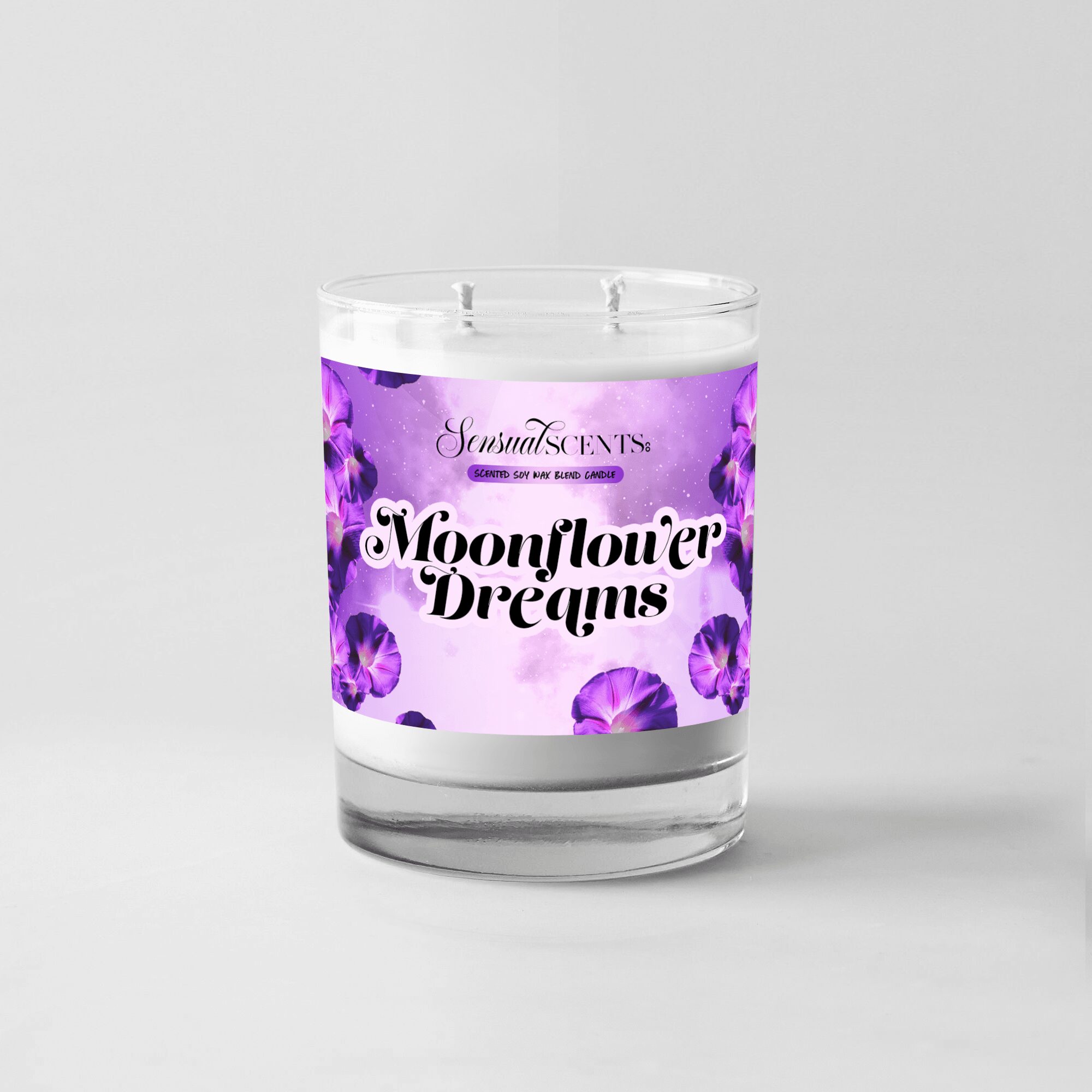 A candle in a glass container with a purple floral label reading 'Moonflower Dreams' and 'Sensual Scents'.