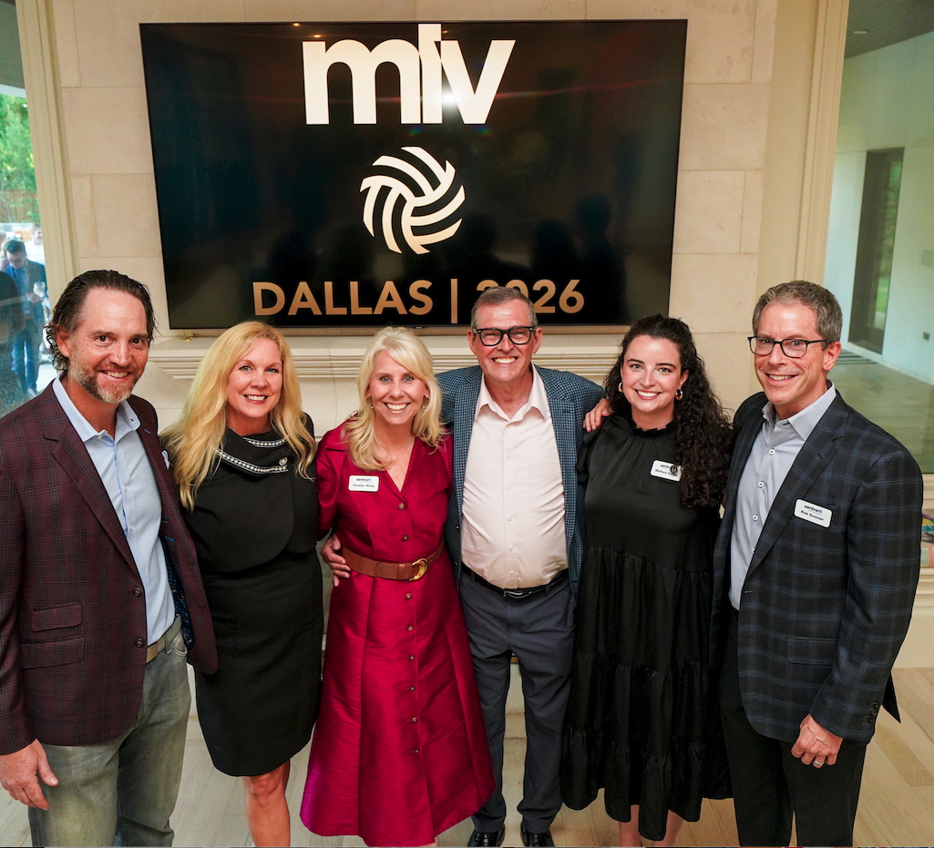 Six people standing together indoors in front of a large screen displaying the MLV logo and Dallas 2026. They are smiling and dressed professionally.