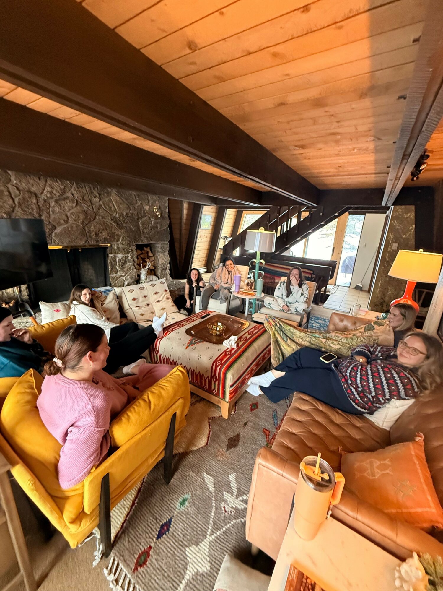Two children and an adult in a living room with furniture, a fireplace, and a patterned carpet, engaging in activities.