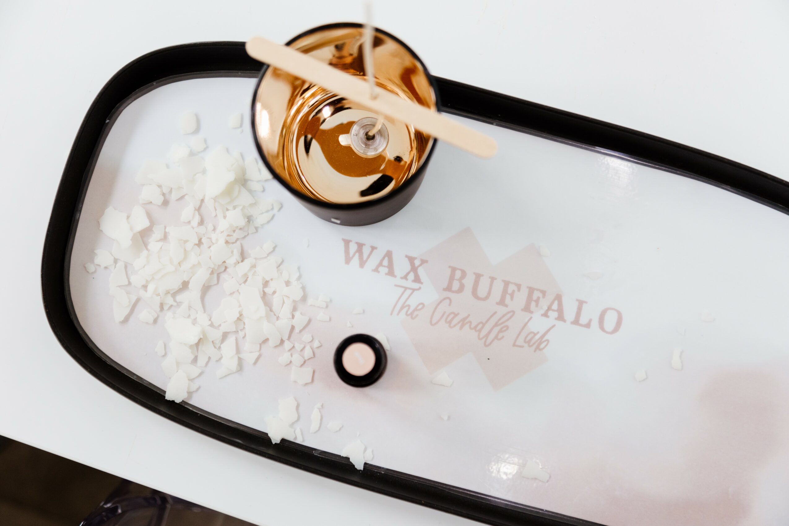 Mirror reflecting wax, powder, and a small container on a white surface, with text partially visible.