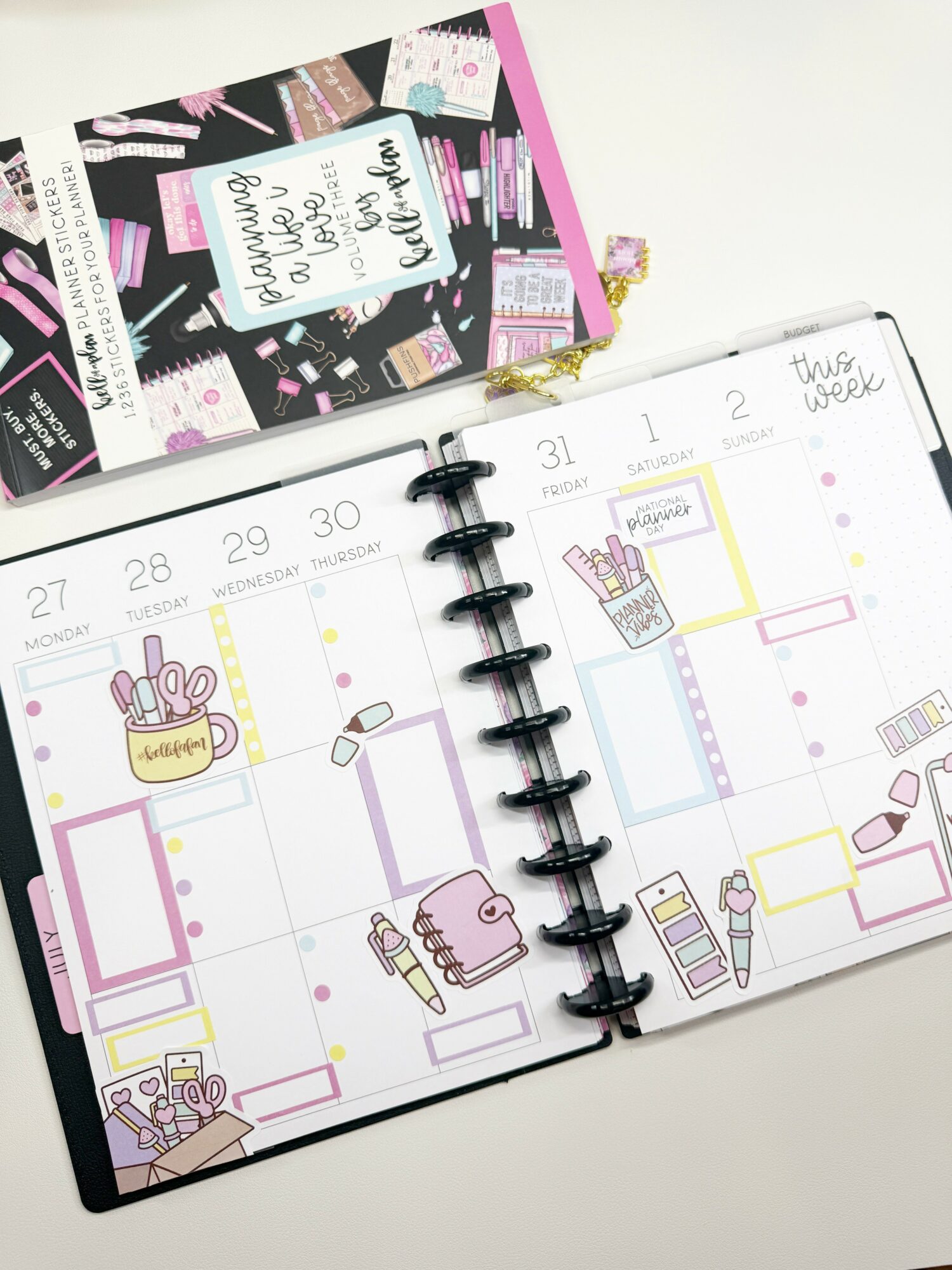 Open planner with weekly schedule, decorated with illustrations of makeup, a bag, and stationery, on a white surface.