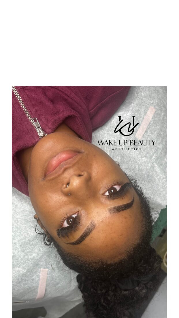 Close-up of a woman's face with makeup, lying down on a surface, wearing a maroon top, with text and logo visible.