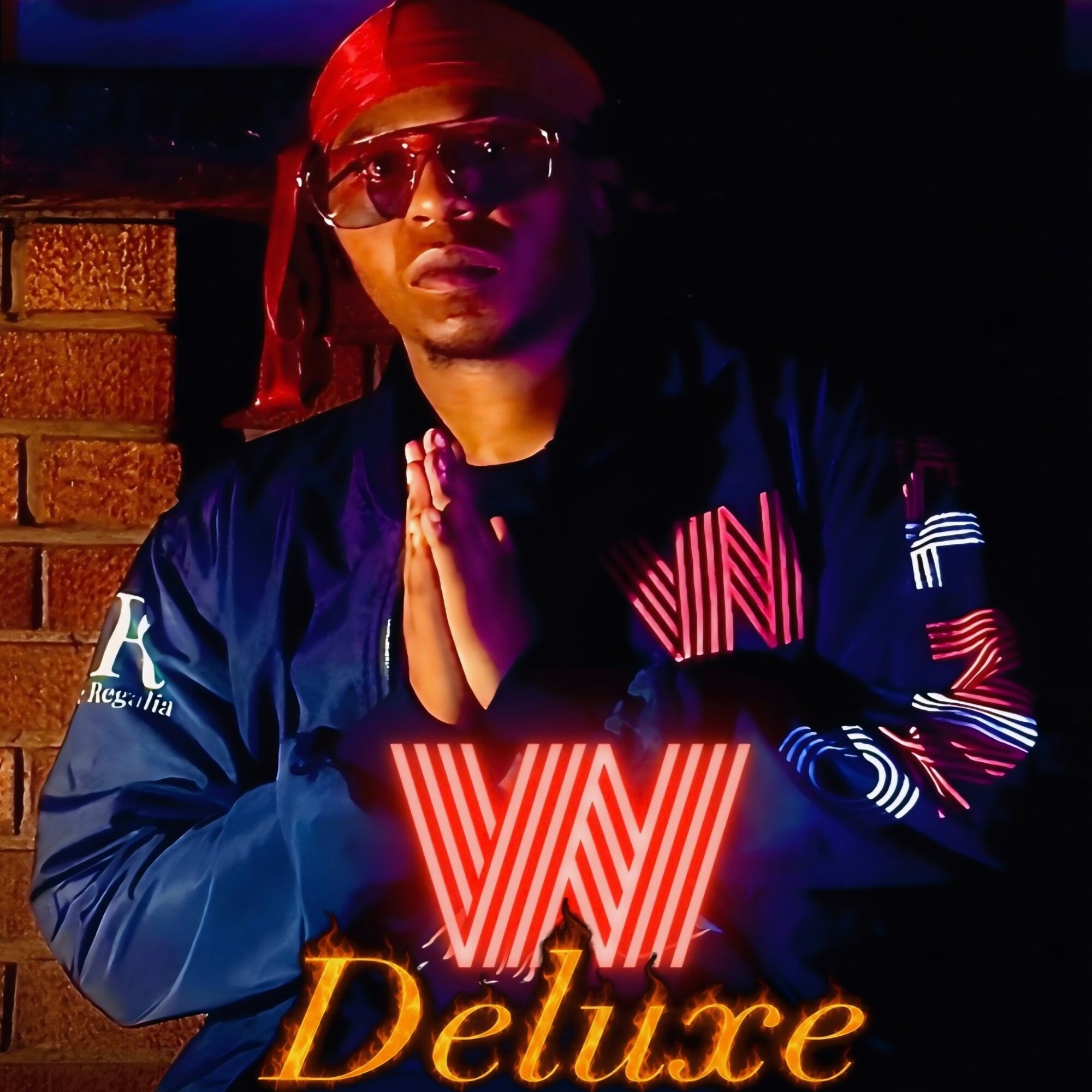 Person wearing sunglasses and a red headscarf, hands together, dark background, illuminated by red and orange lights.