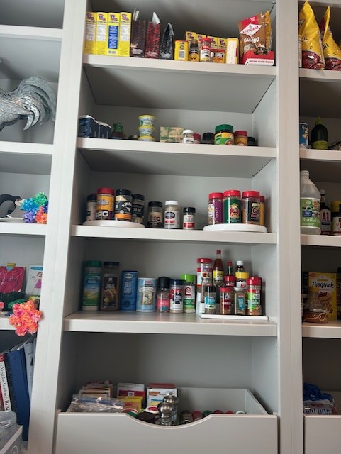 Shelves filled with various jars, bottles, and boxes of food and supplements, organized on multiple shelves.