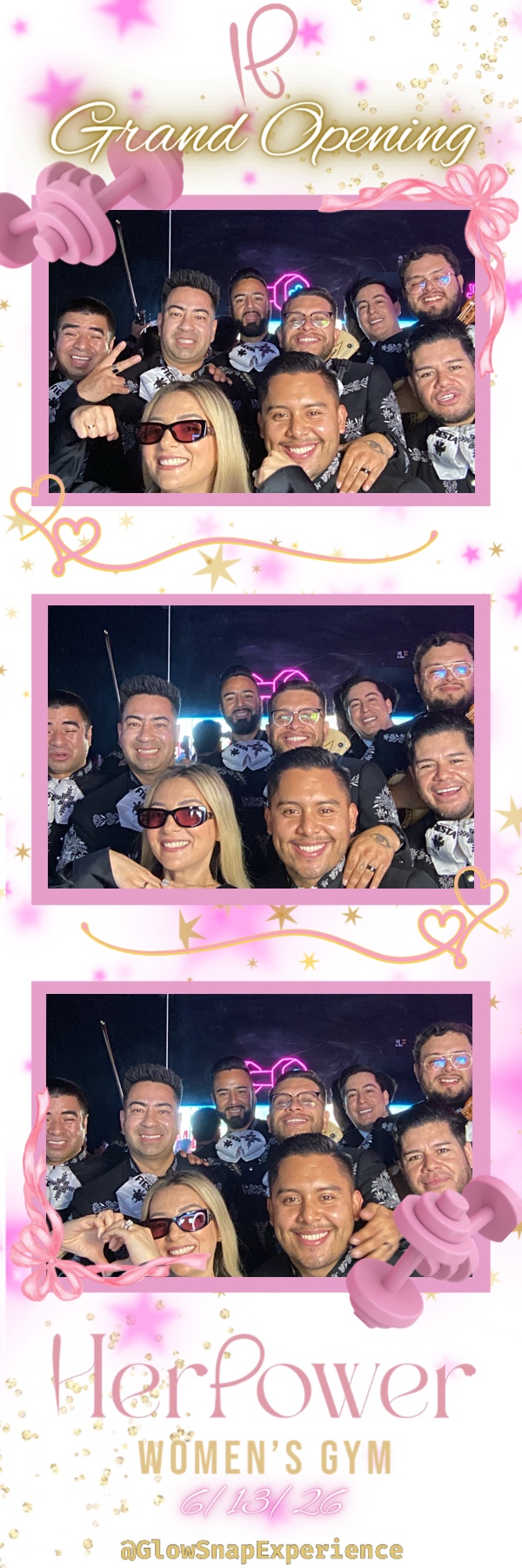 Group of people smiling at a celebration with pink decorations and a sign reading 'Grand Opening' and 'Her Power Women's Gym'.