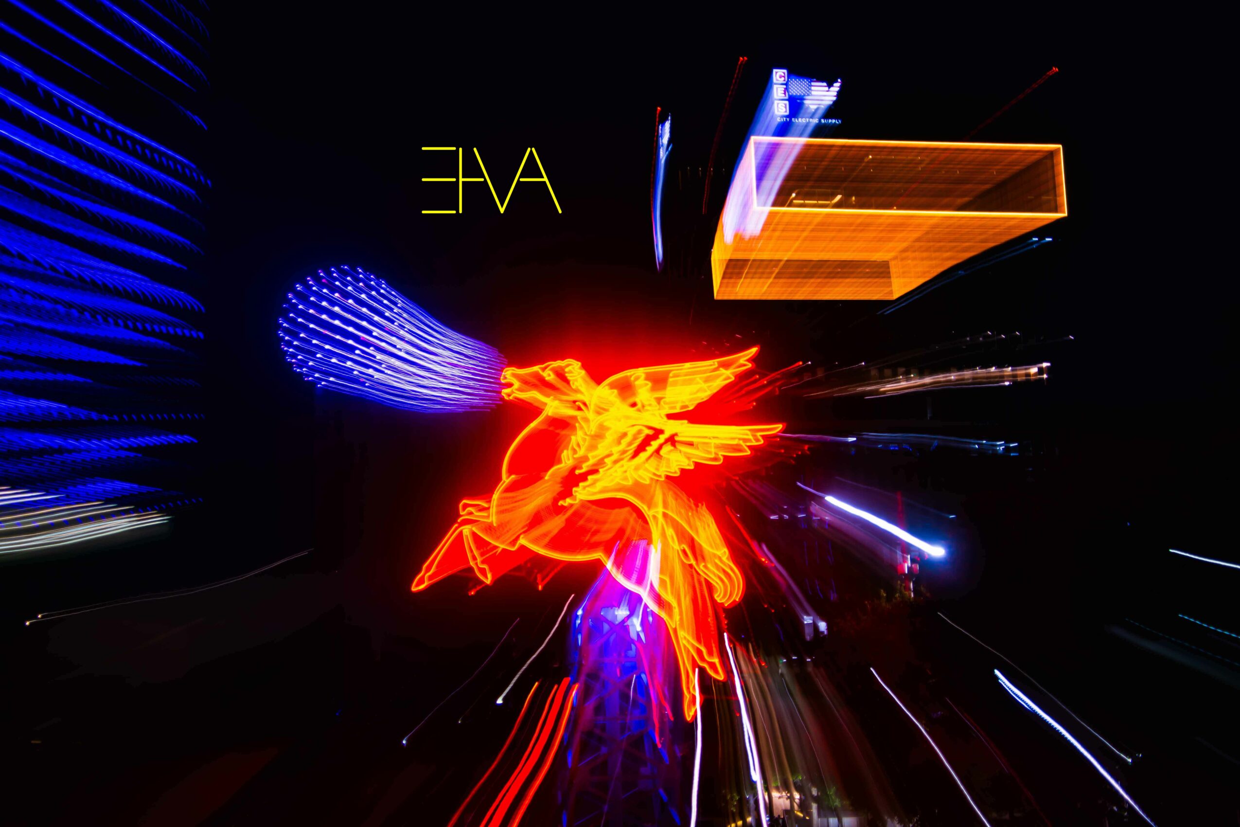 Light trails and neon signs in a dark setting with bright blue, orange, and red colors.