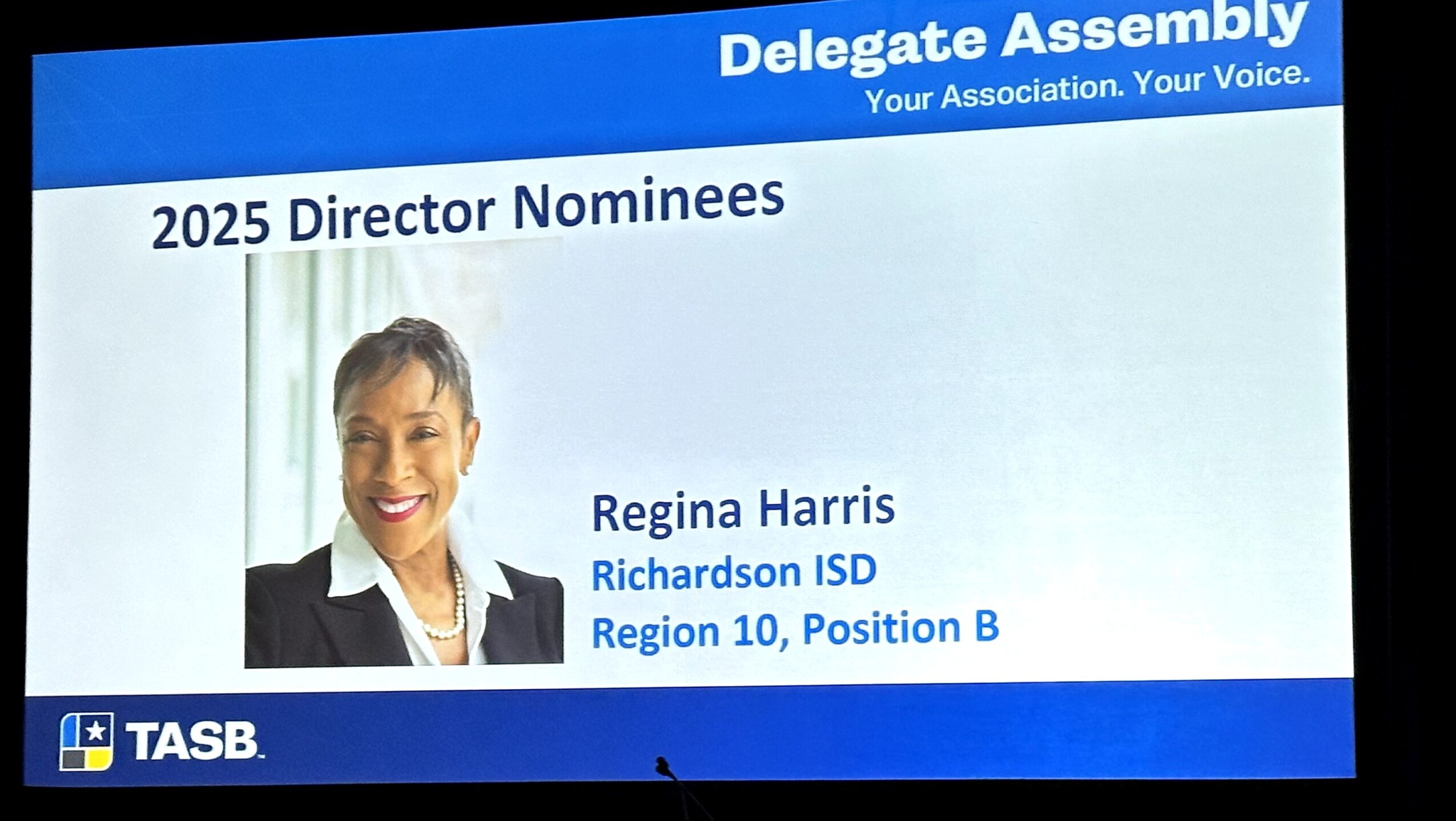 Name tag displaying Regina Harris as a 2025 director nominee, with her photo and details, on a blue background.