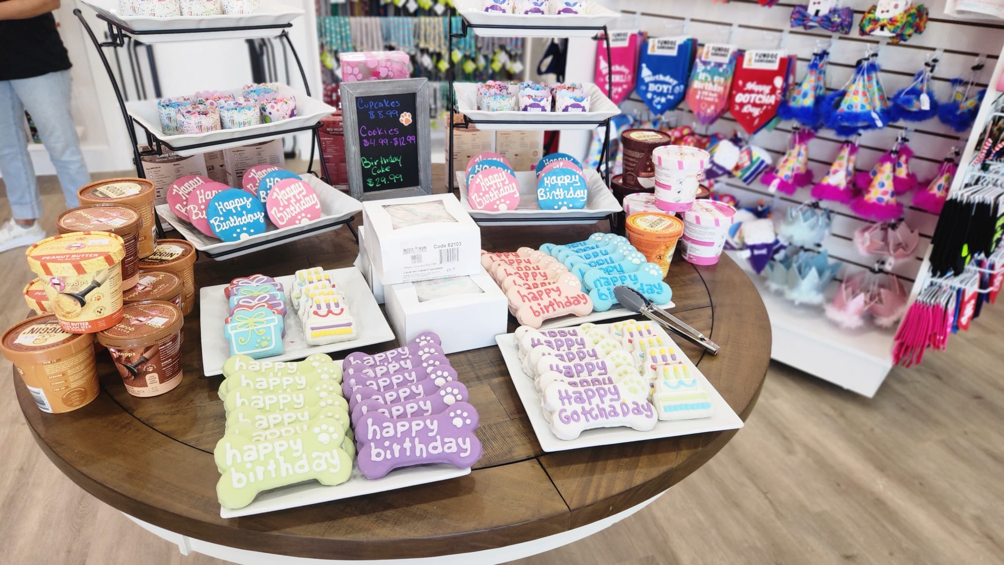 Table displays birthday-themed items including towels, gift boxes, and party favors in a store.