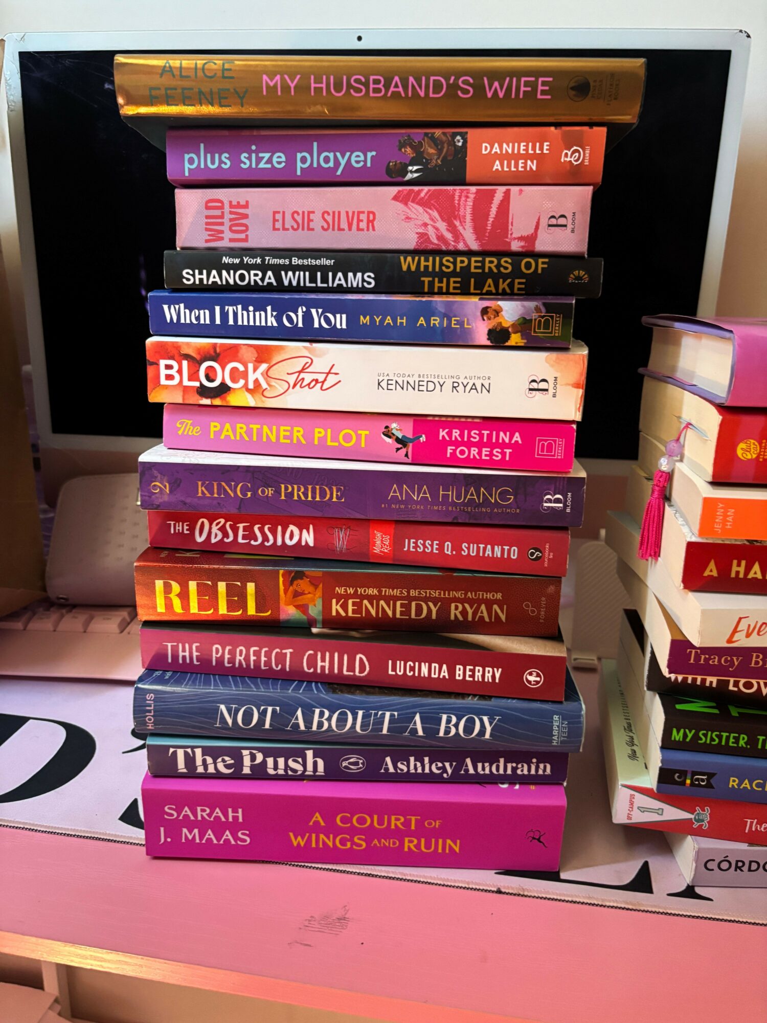 Books arranged on a pink shelf, with titles related to romance, relationships, and personal growth.