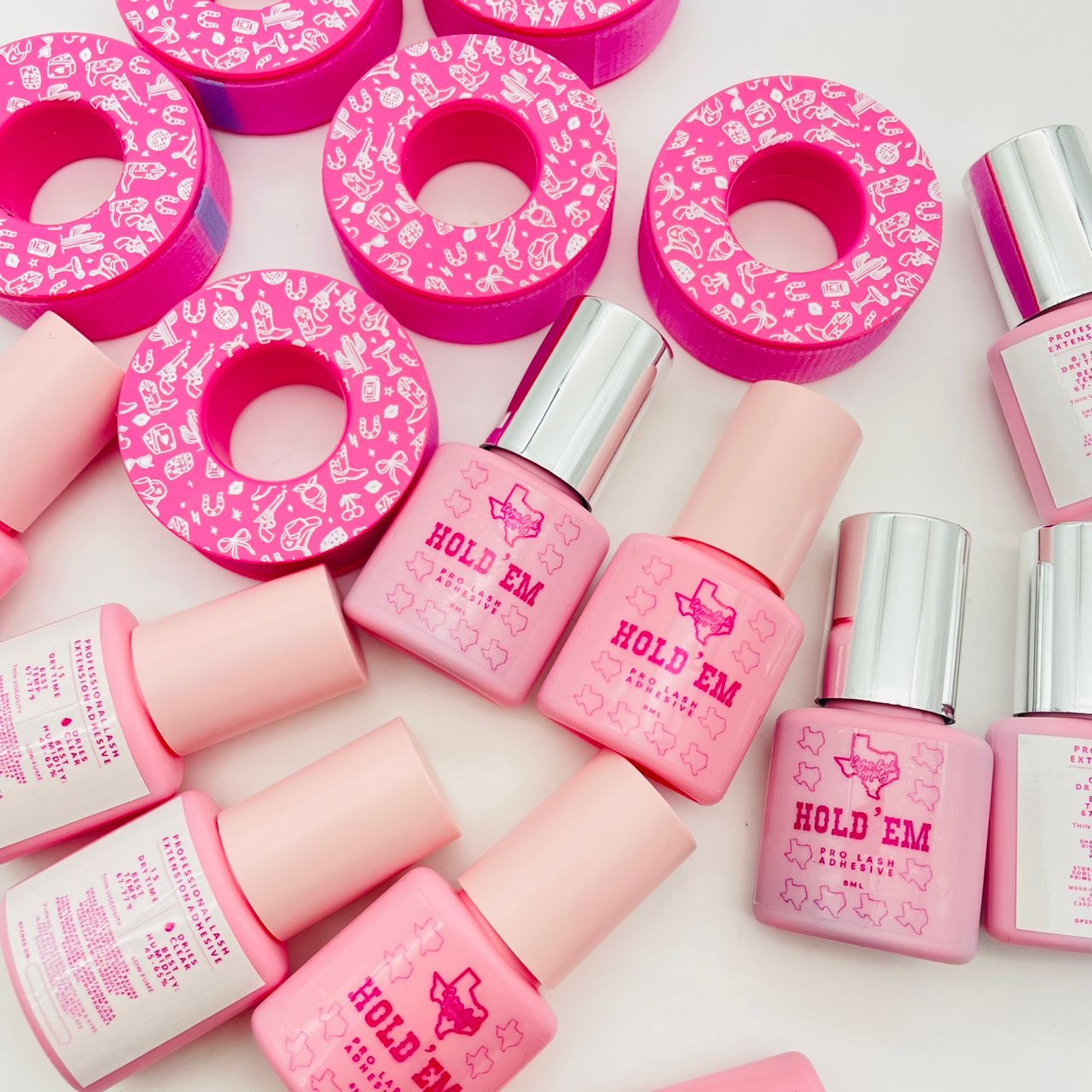 Pink bottles and pink donut-shaped objects with white patterns on a white background.
