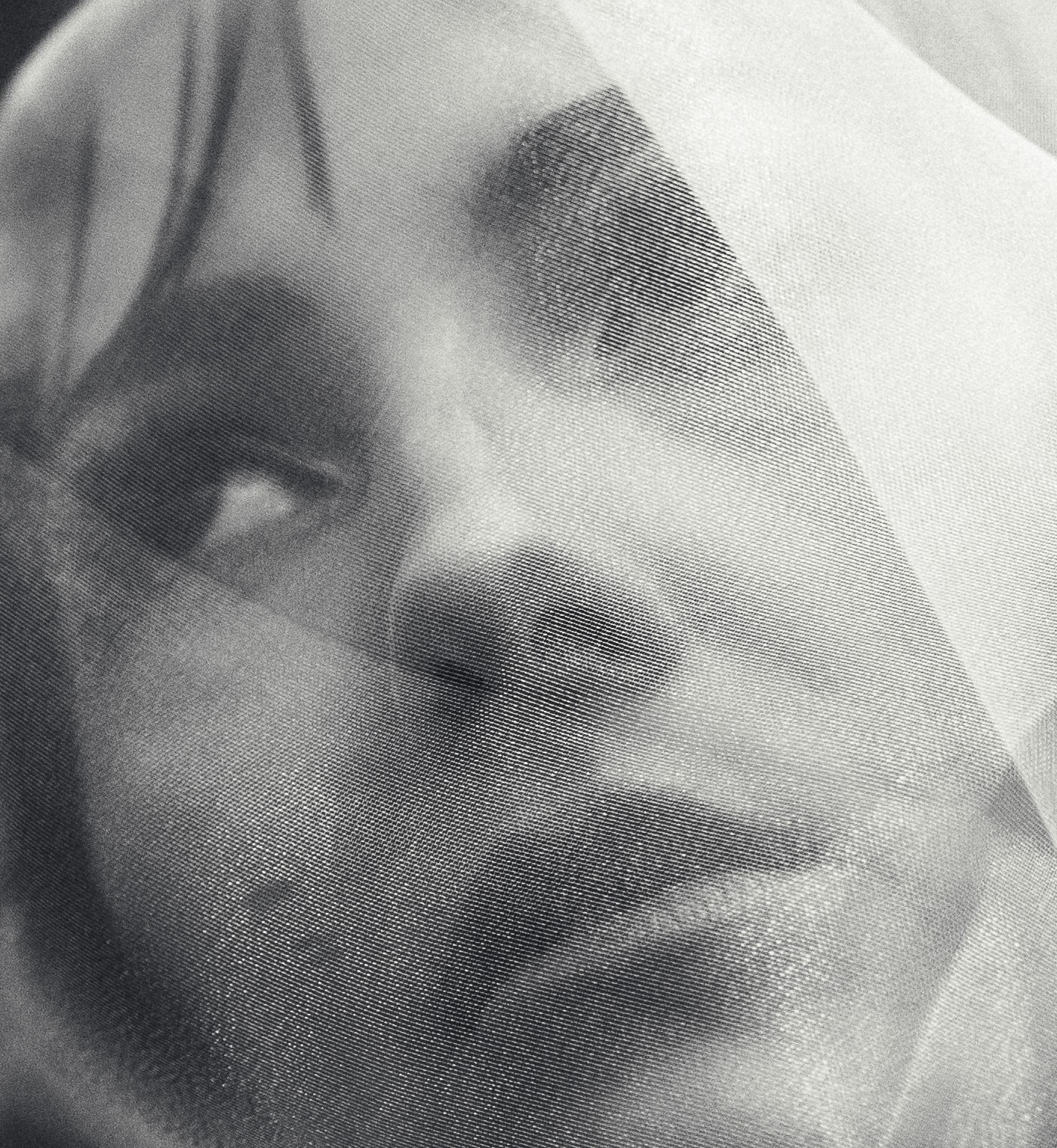Close-up of a person's face with eyes looking upward, partially obscured by a translucent material.