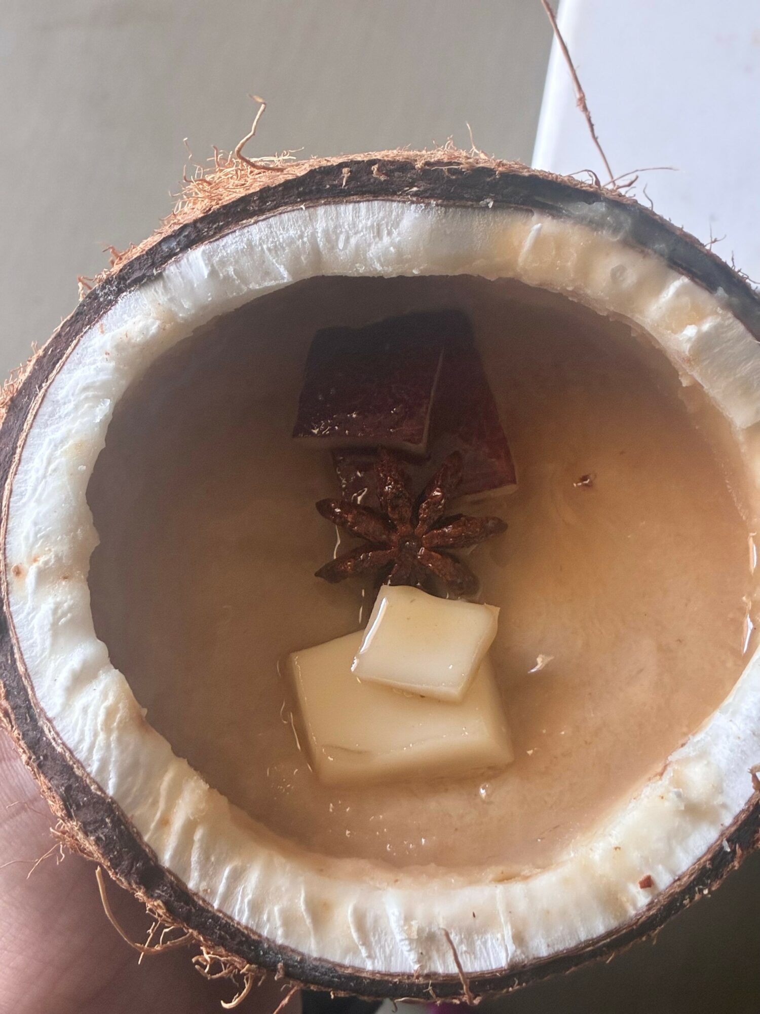 Coconut shell with a star-shaped object and small blocks inside, possibly a drink or decoration.