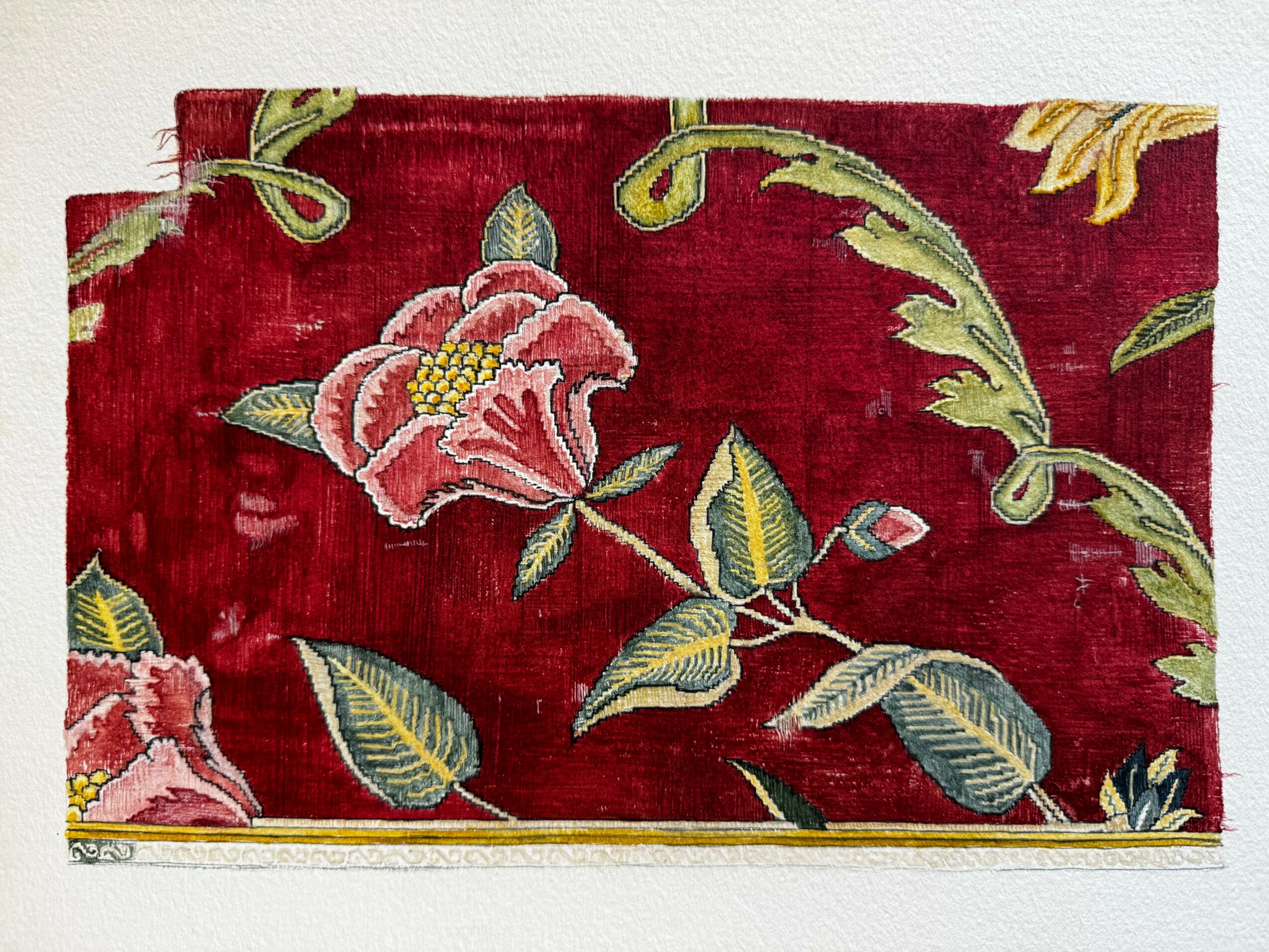 Decorative textile with pink flowers and green leaves on a red background.