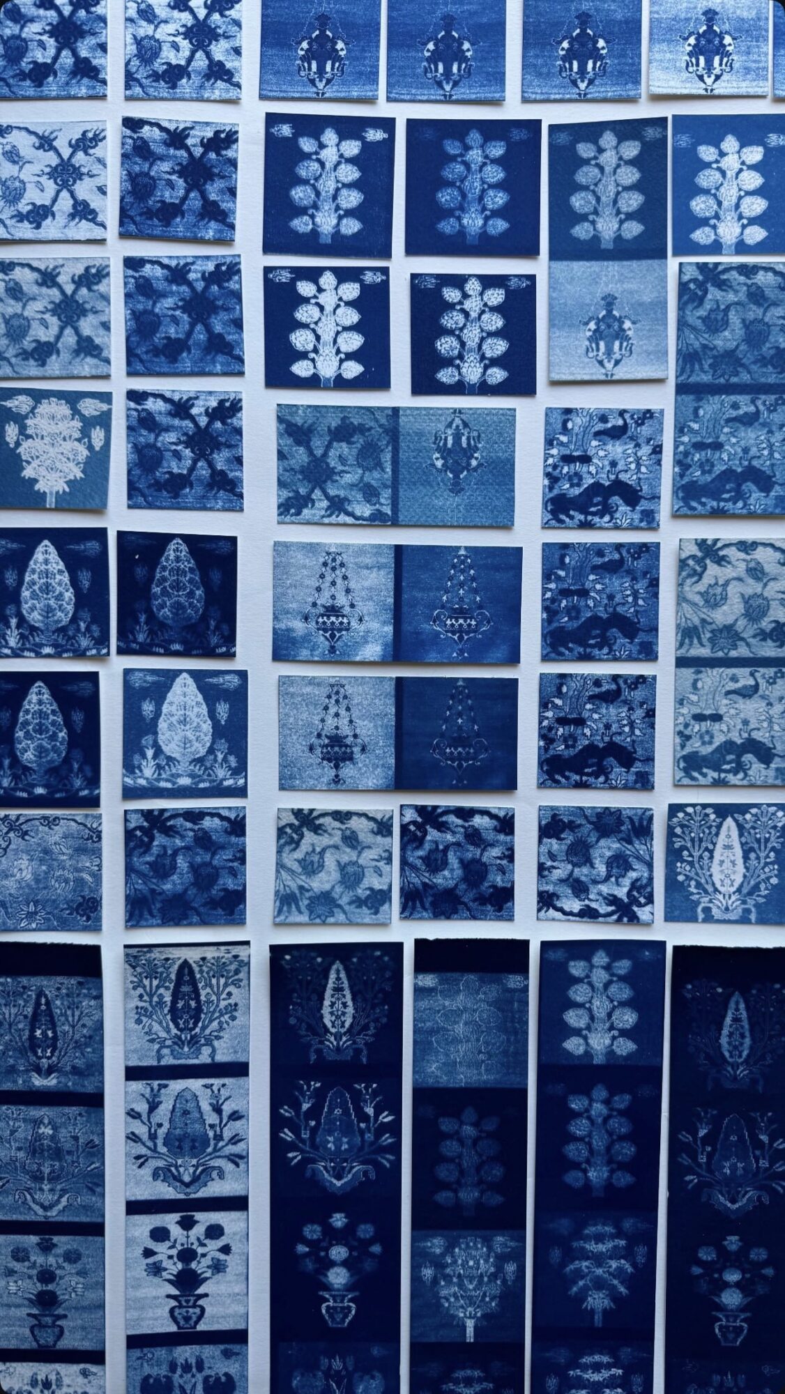 Collection of blue and white patterned tiles with floral and geometric designs, arranged in a grid.