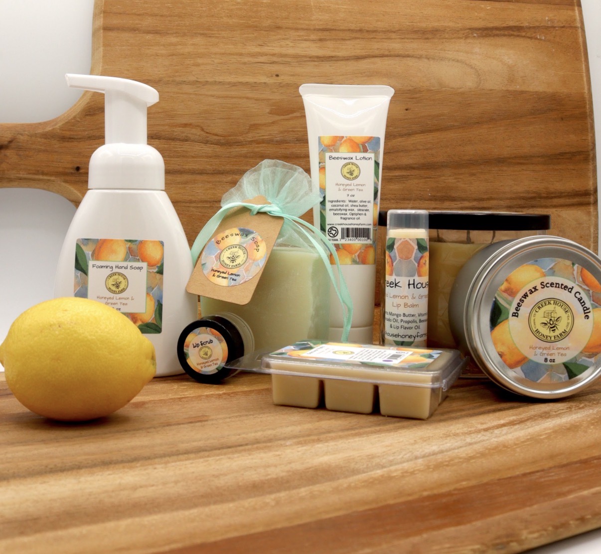 Collection of skincare and cosmetic products on a wooden surface with a lemon in front.