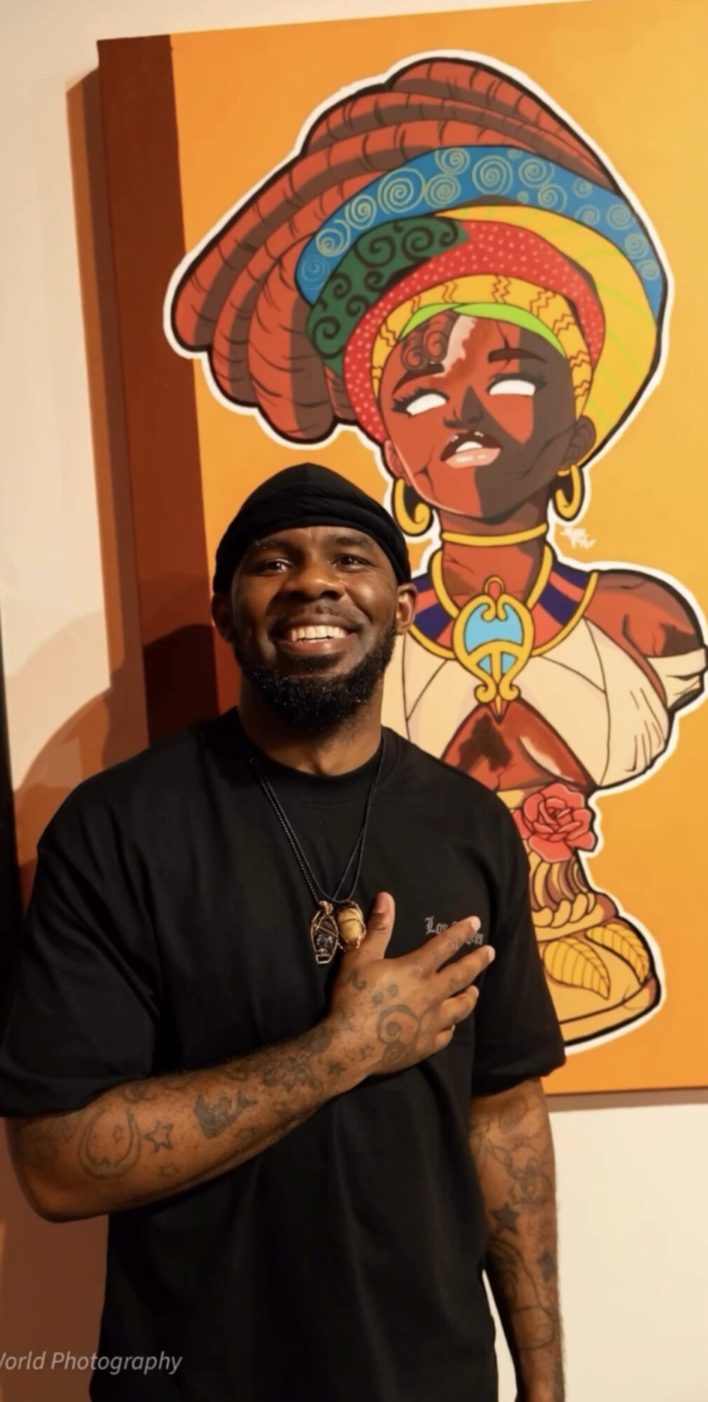 Man smiling with hand on chest in front of colorful cartoon woman with large hair and jewelry