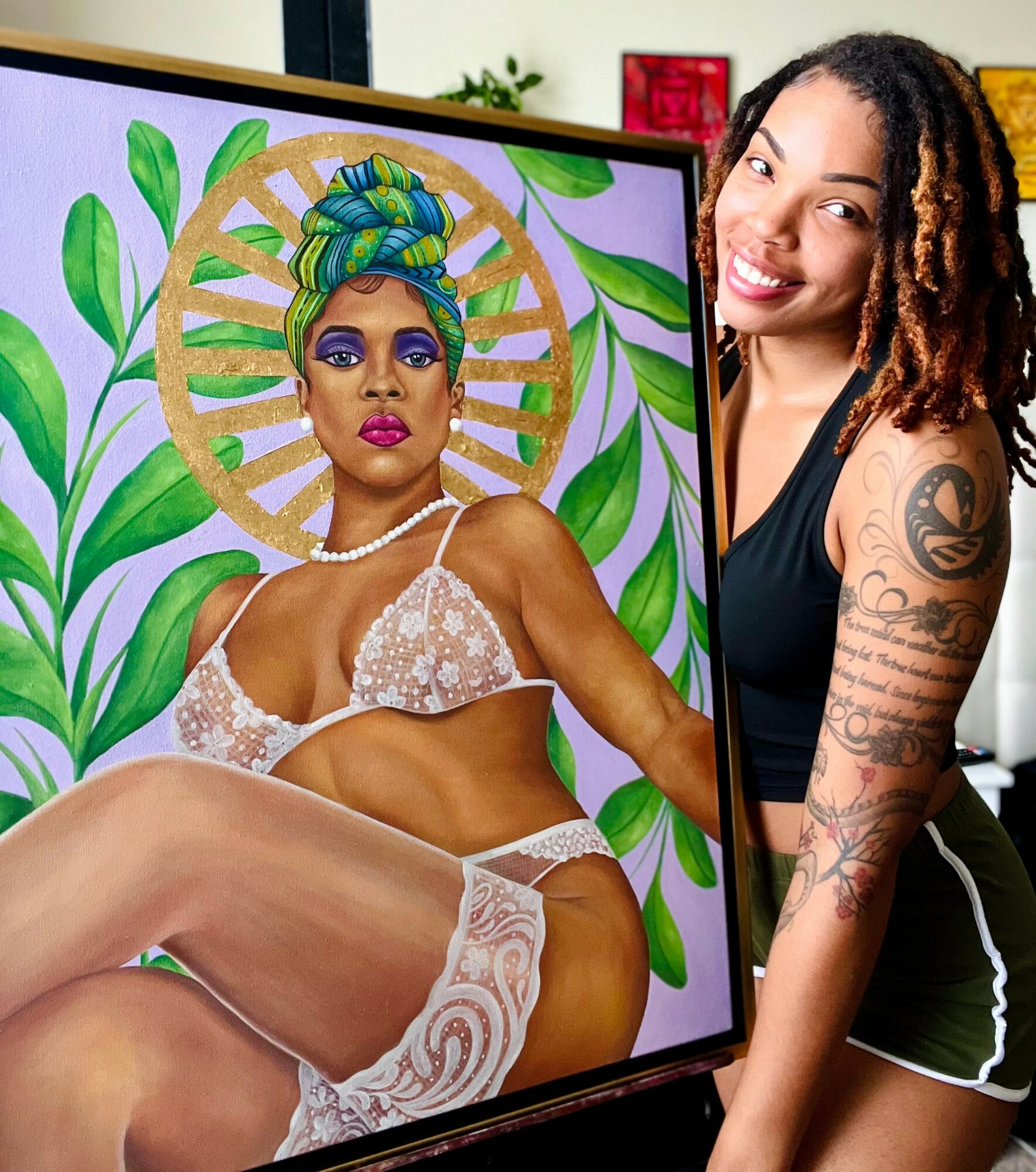 Artist working on a colorful portrait of a woman with a headwrap, jewelry, and lingerie, surrounded by green leaves background.