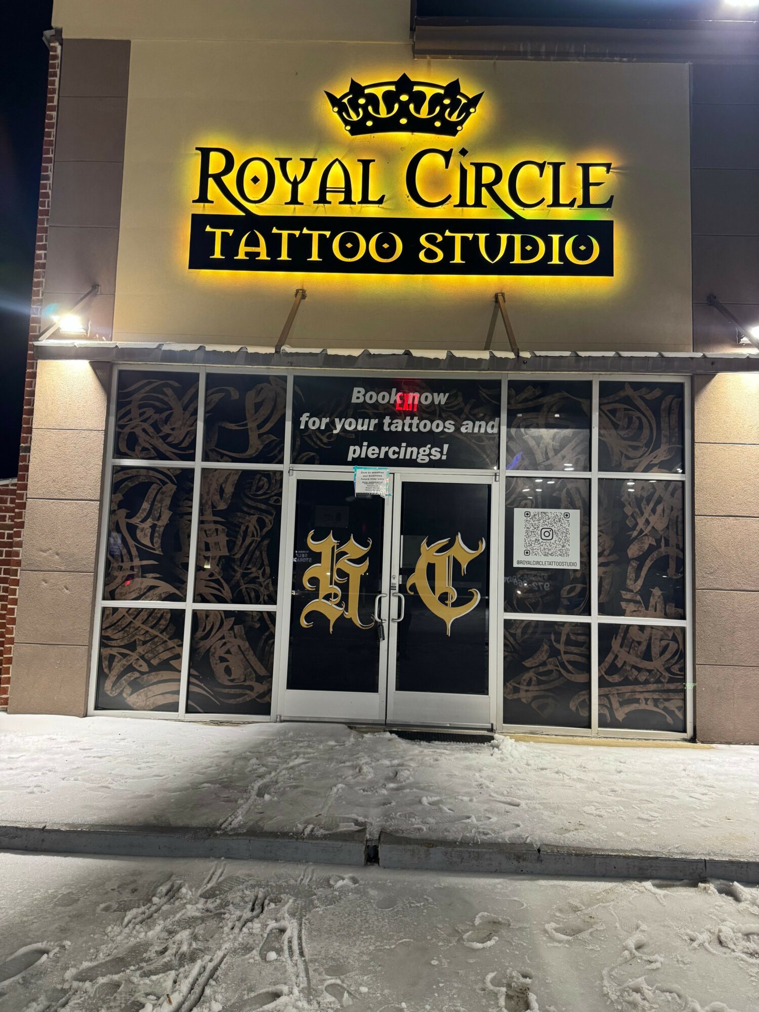 Tattoo studio storefront with a yellow and black sign reading 'Royal Circle Tattoo Studio' and a window display.