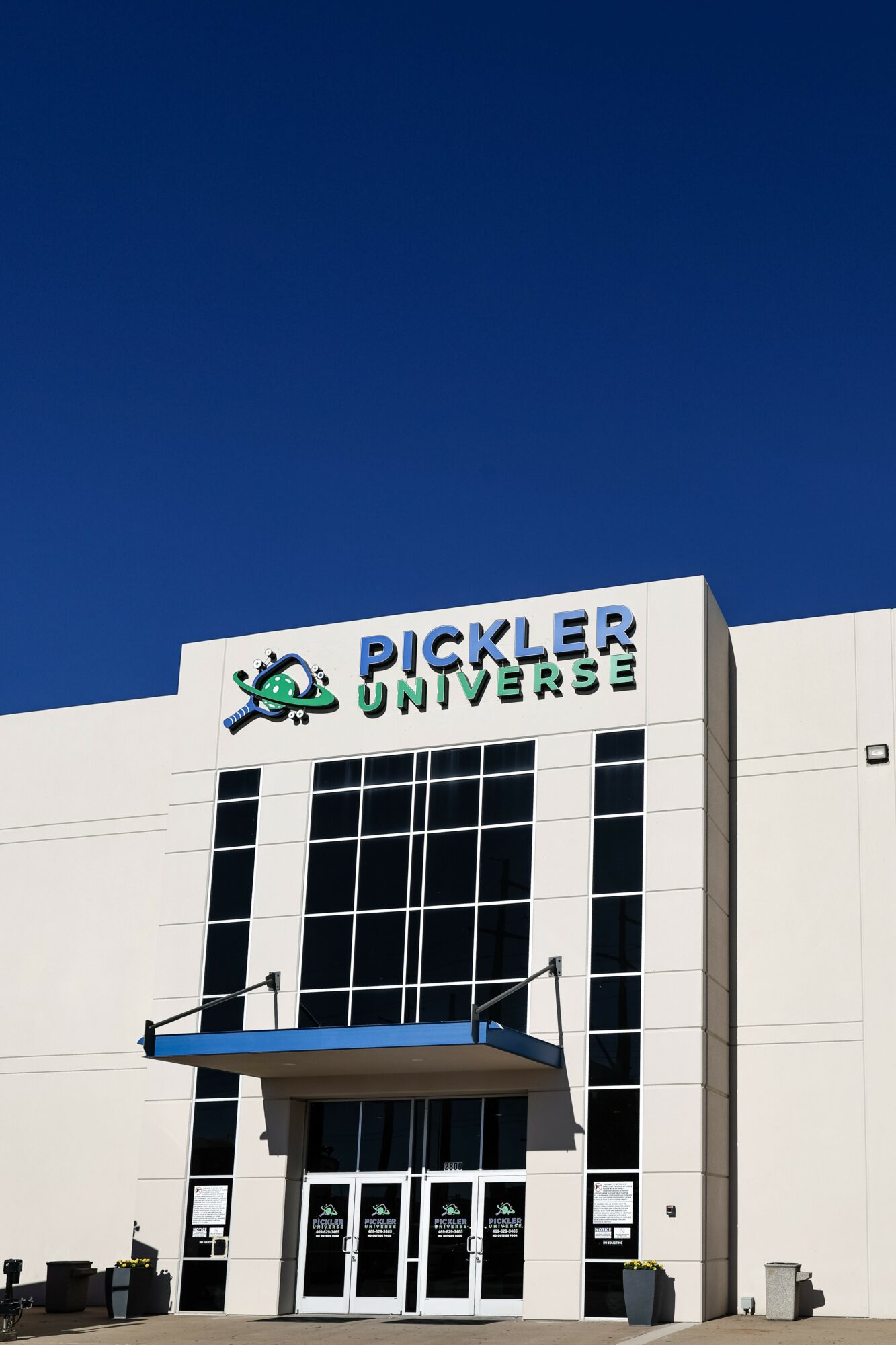 Building with Pickler Universe sign, glass windows, and a blue sky background.