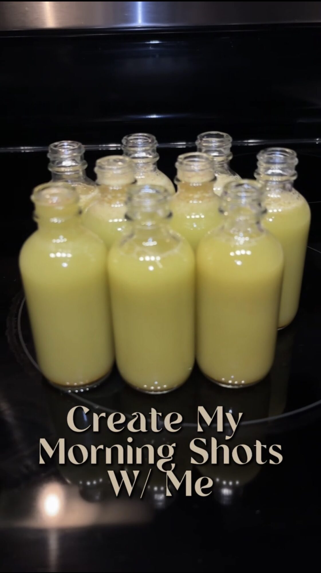 Multiple bottles filled with yellow liquid arranged on a surface with text reading 'Create My Morning Shots W Me'.