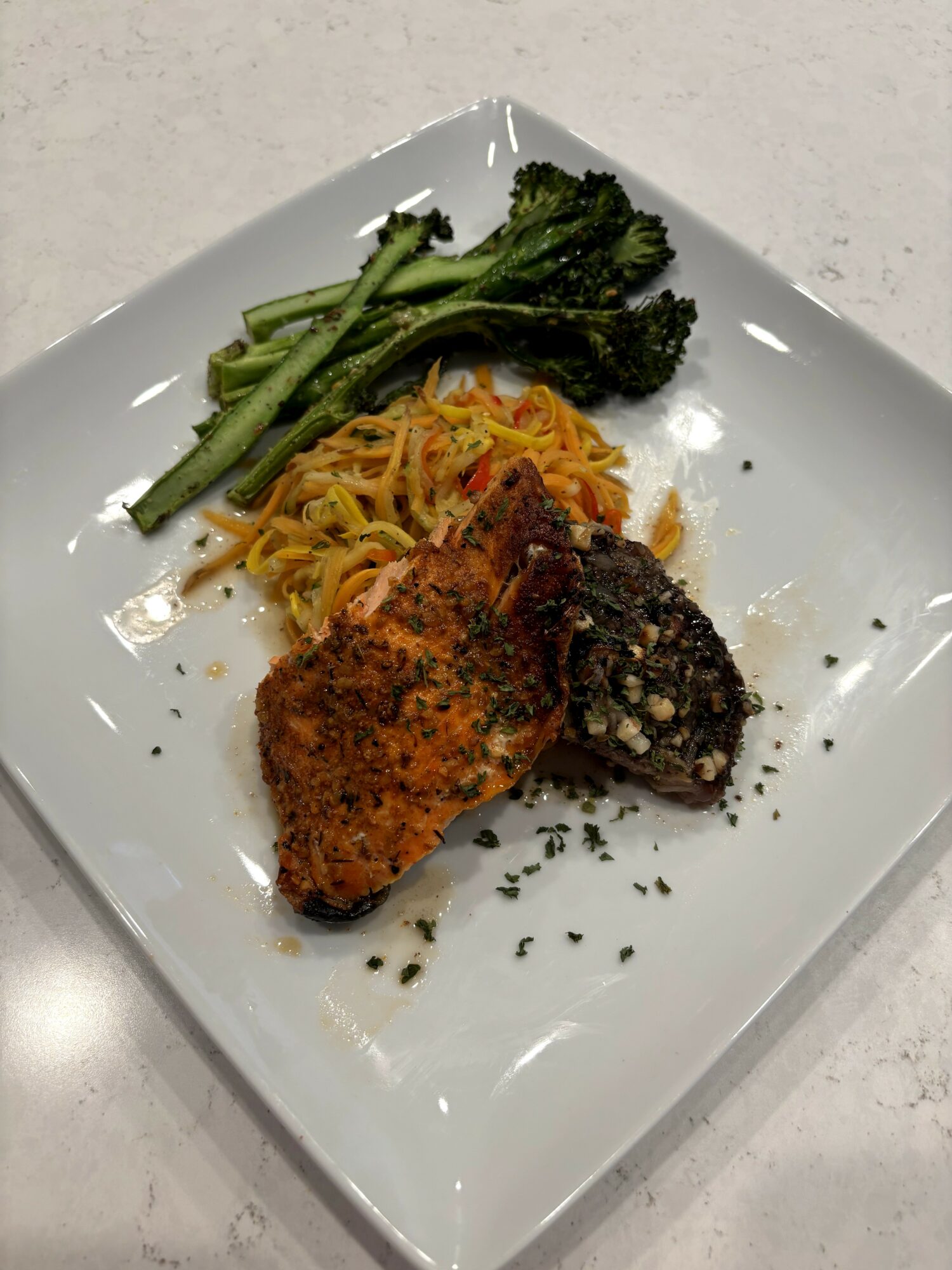 Plate with green broccoli, spaghetti with sauce, and a breaded fried item with a dark filling, sprinkled with herbs.